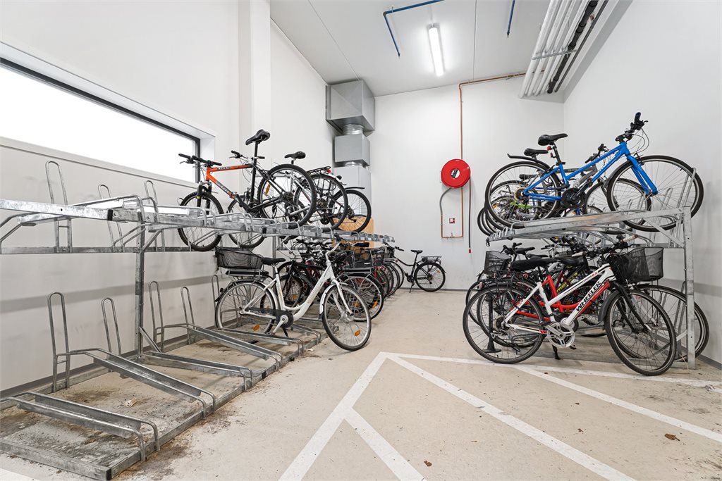 Felles sykkelparkering med stativ. 