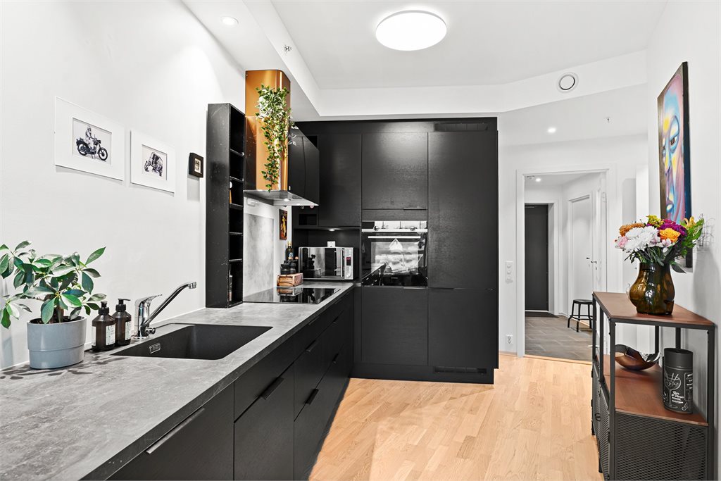 Kjøkkenet har en lekker innredning med sorte fronter og integrerte hvitevarer.