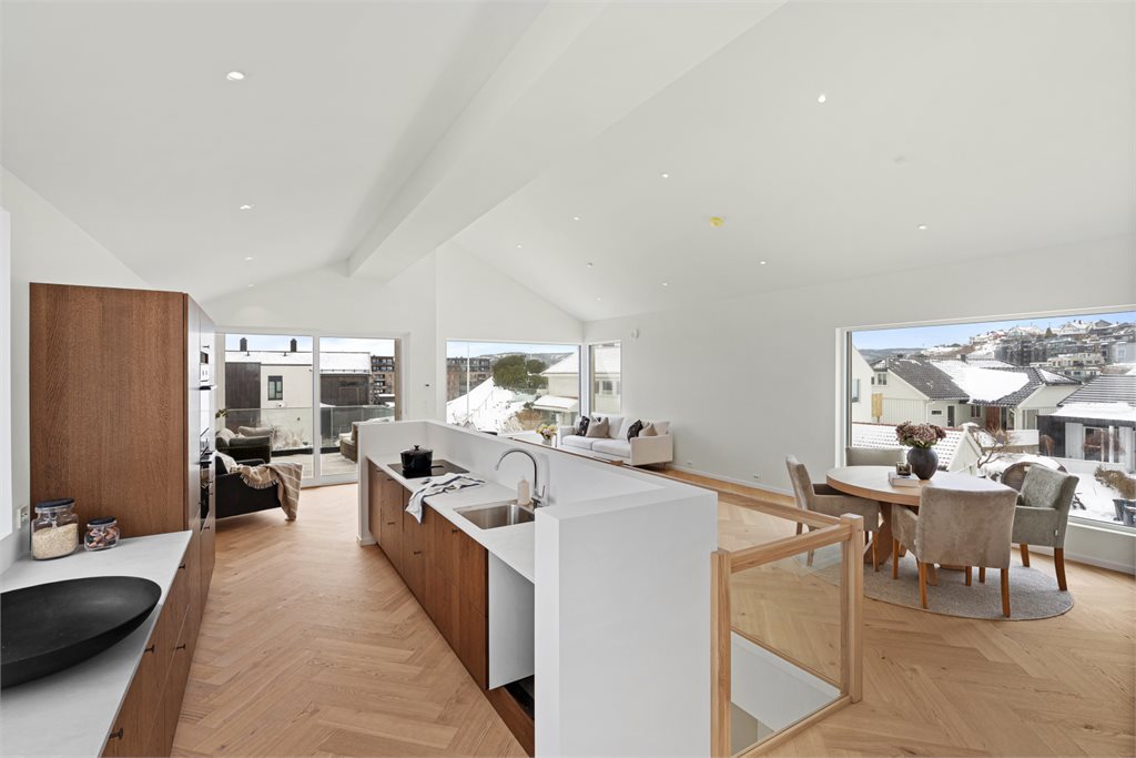 Stuen glir sømløst over i et lekkert Strai-kjøkken i fargen Mocca, med laminert benkeplate og gjennomtenkte løsninger.