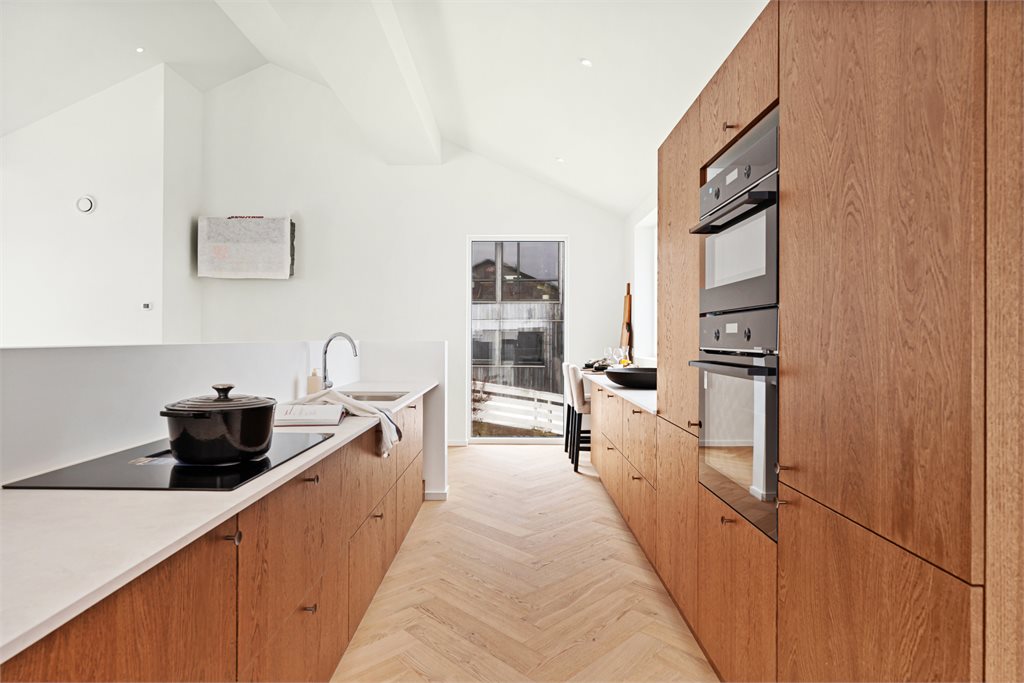 Kjøkkenet er både funksjonelt og estetisk, med gode arbeidsflater og smart oppbevaring.