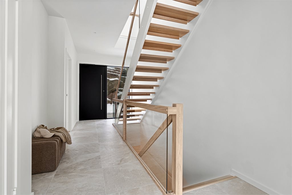 Boligen ønsker deg velkommen med en romslig og innbydende entré. Her er det lagt store fliser i Salt Rock White Gold 60x60.