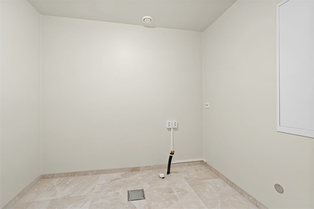 Vaskerommet er romslig og funksjonelt, med god plass til både vask, tørk og oppbevaring.