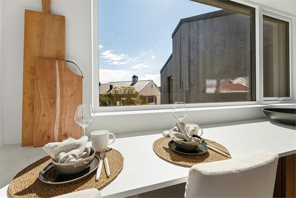 Spiseplass med utsyn mot uteområde og arkitektonisk uttrykk.
