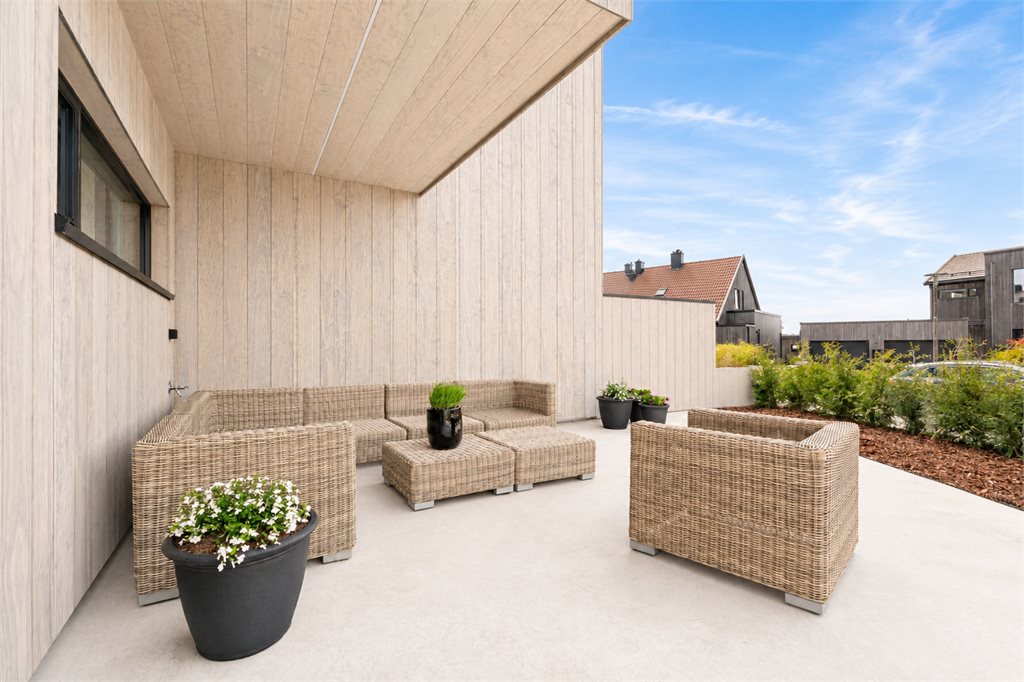 Skjermet uteplass med god sittegruppe og moderne uttrykk.