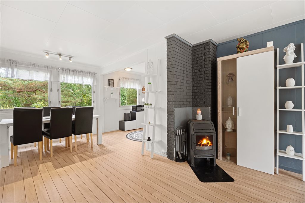 Lys og innbydende spiseplass i åpen løsning med peisovn