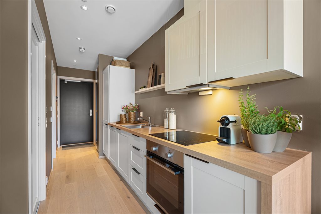 Kjøkkenet har en praktisk utforming med integrerte hvitevarer. 