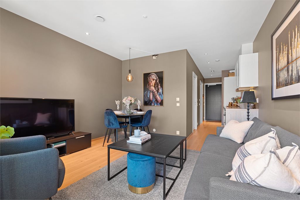 Det er åpen løsning mot kjøkkenet, de store vinduene slipper inn rikelig med lys.