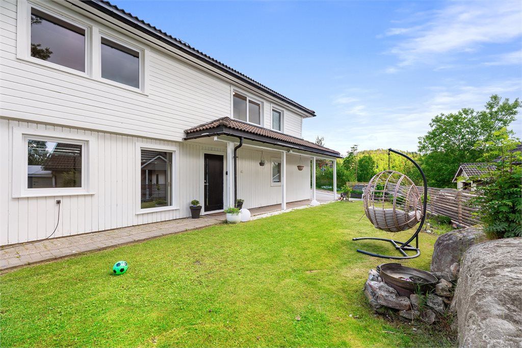 Boligen sett fra hagesiden med pent opparbeidet uteområde