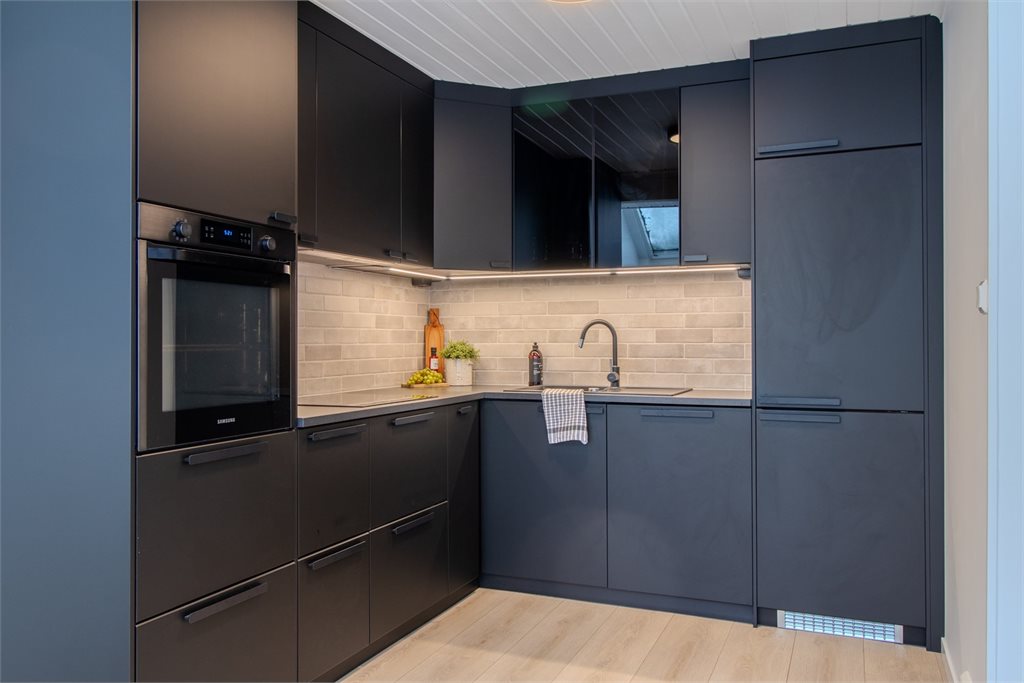 Kjøkken med integrerte hvitevarer og praktisk arbeidsflate.