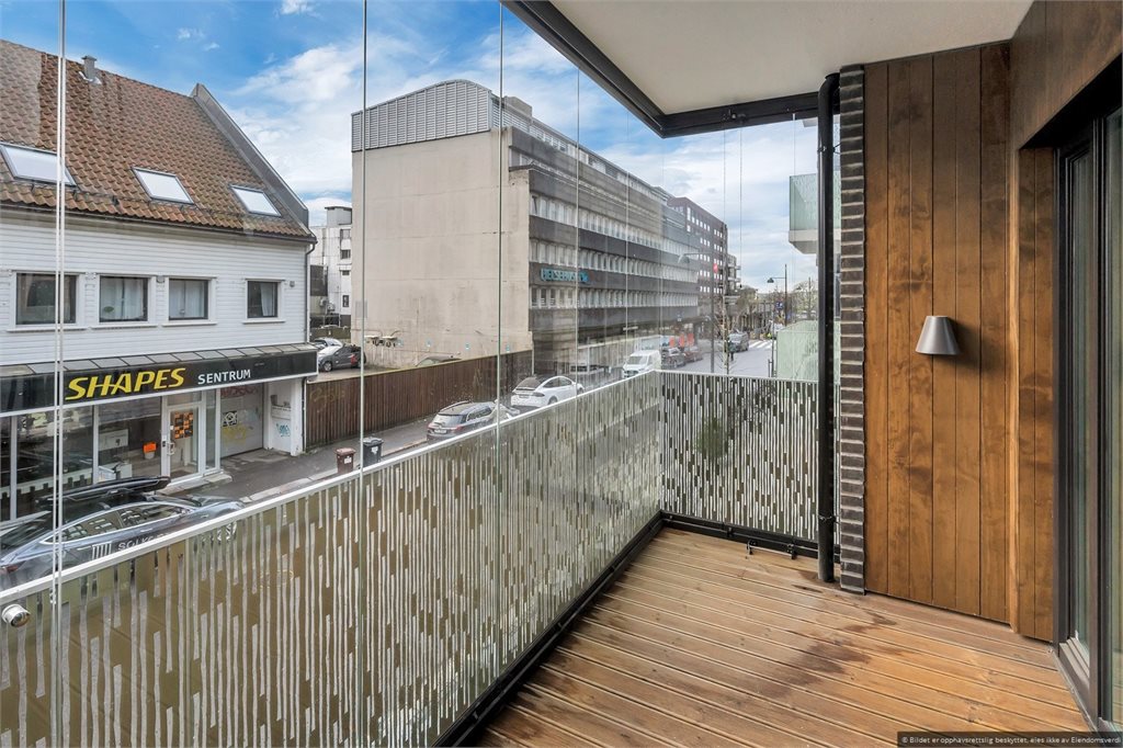 Romslig innglasset balkong med god plass til utemøbler!