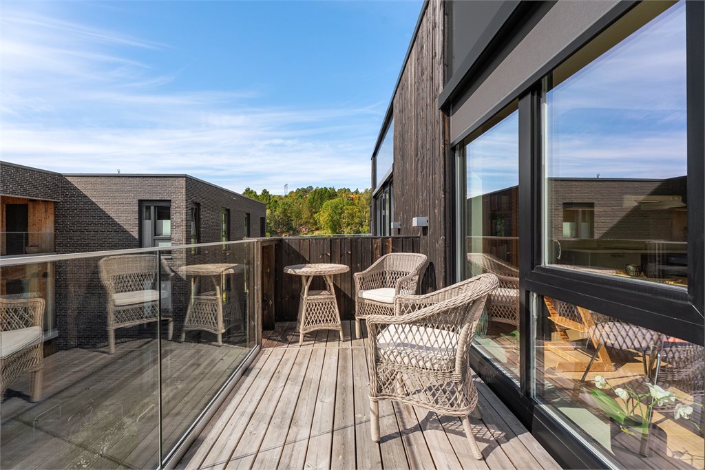 Solrik sørvendt balkong i toppetasjen, som fungerer som et naturlig samlingspunkt.