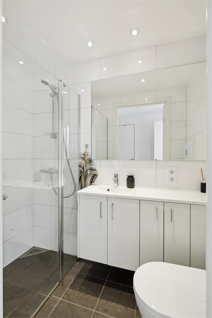 Bad 2 med dusjdører, romslig servant og toalett. 