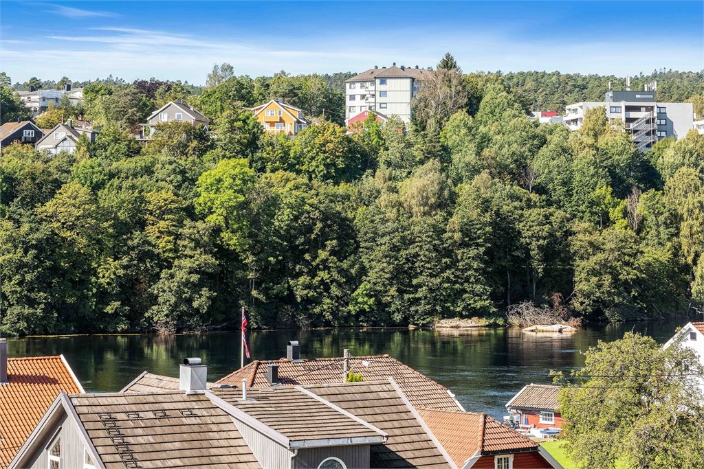 Zoomet bilde fra balkong med utsikt mot Otra fra 2023