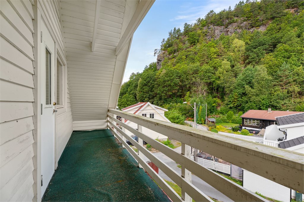 Balkong med utsyn mot nærområdet og den grønne åssiden.