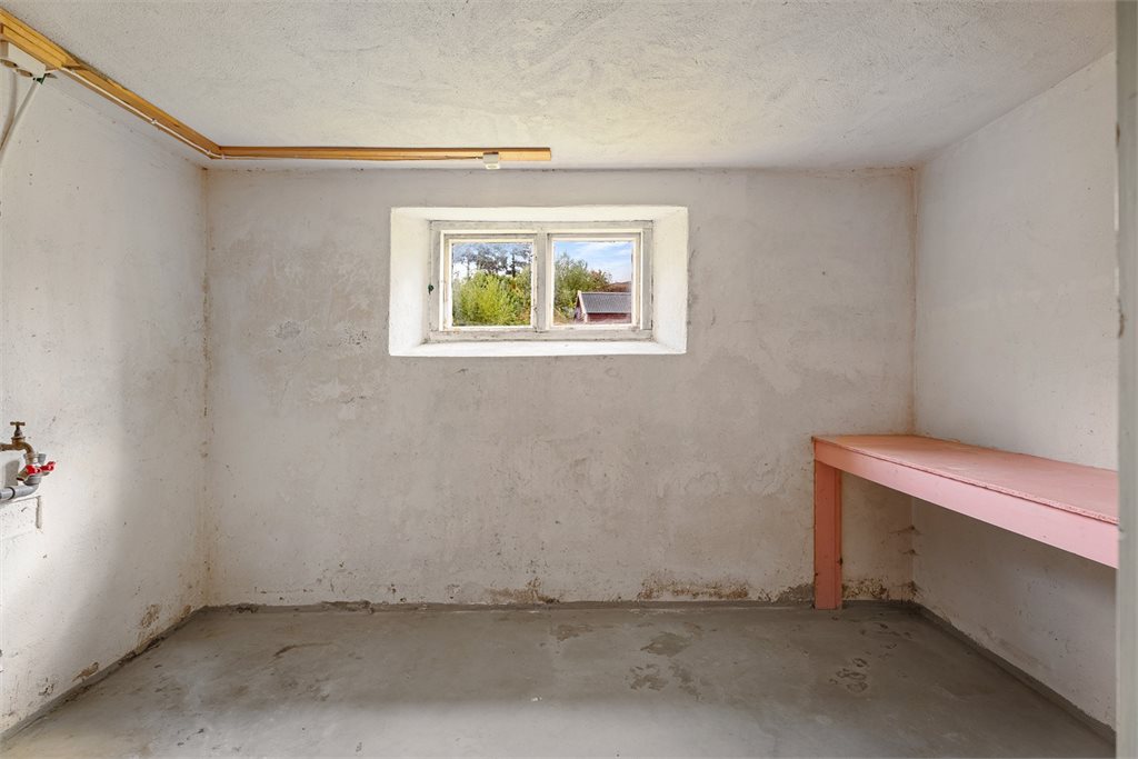 Praktisk rom i underetasjen med vindu, arbeidsbenk og vannuttak.