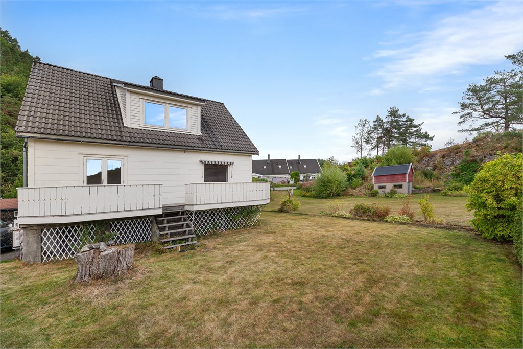 Boligen har en romslig hage med plen, terrasse og god plass til ulike uteaktiviteter.