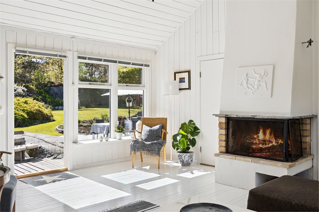 Stue og kjøkken i åpen løsning med god takhøyde og koselig atmosfære - perfekt for samvær og hyggelige måltider.