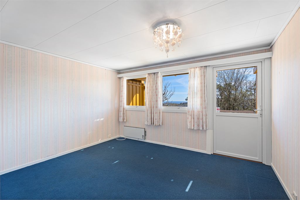 Fra dette soverommet er det utgang til uteplass i front av boligen. 