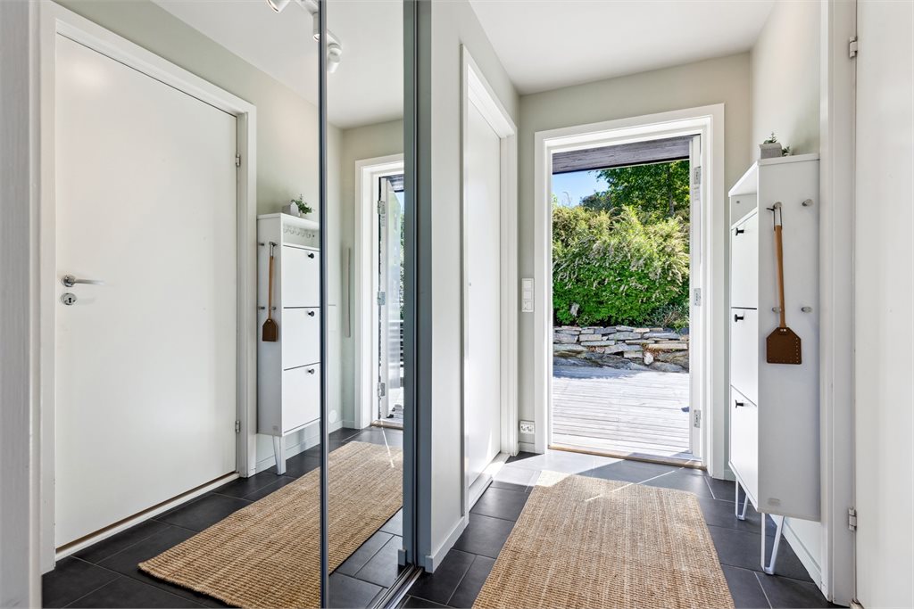 Det er praktisk skyvedørsgarderobe med plass til å henge av seg yttertøy og sette fra seg sko i gangen.