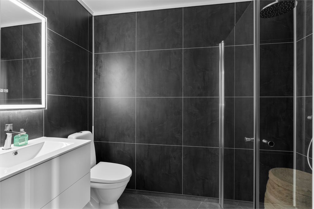 Badet er innredet med servant m/speil toalett og dusjhjørne. Opplegg for vaskemaskin. 