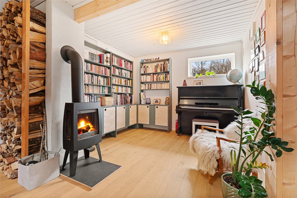 Stemningsfull stue med peis og lune materialer.
