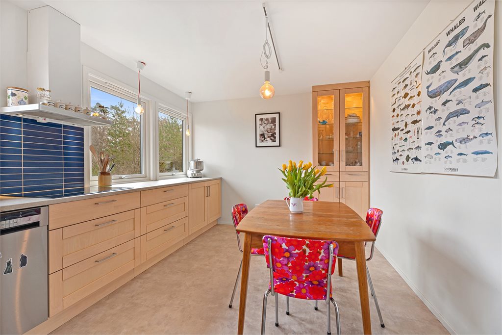 Kjøkken med god arbeidsflyt og plass til spisebord.
