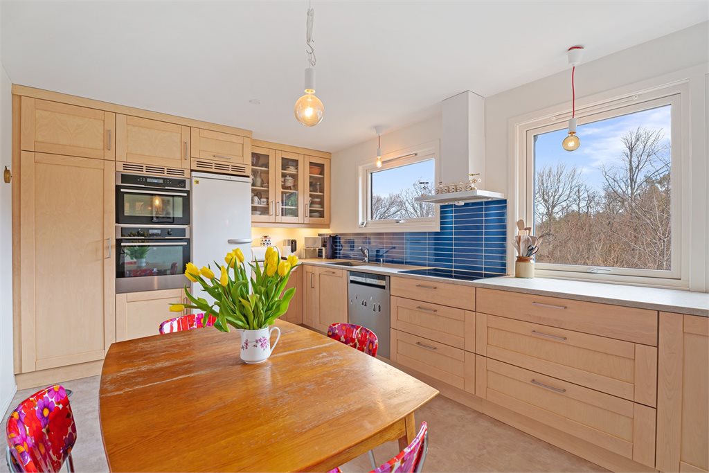 Praktisk kjøkken med rikelig skap og benkeplass.
