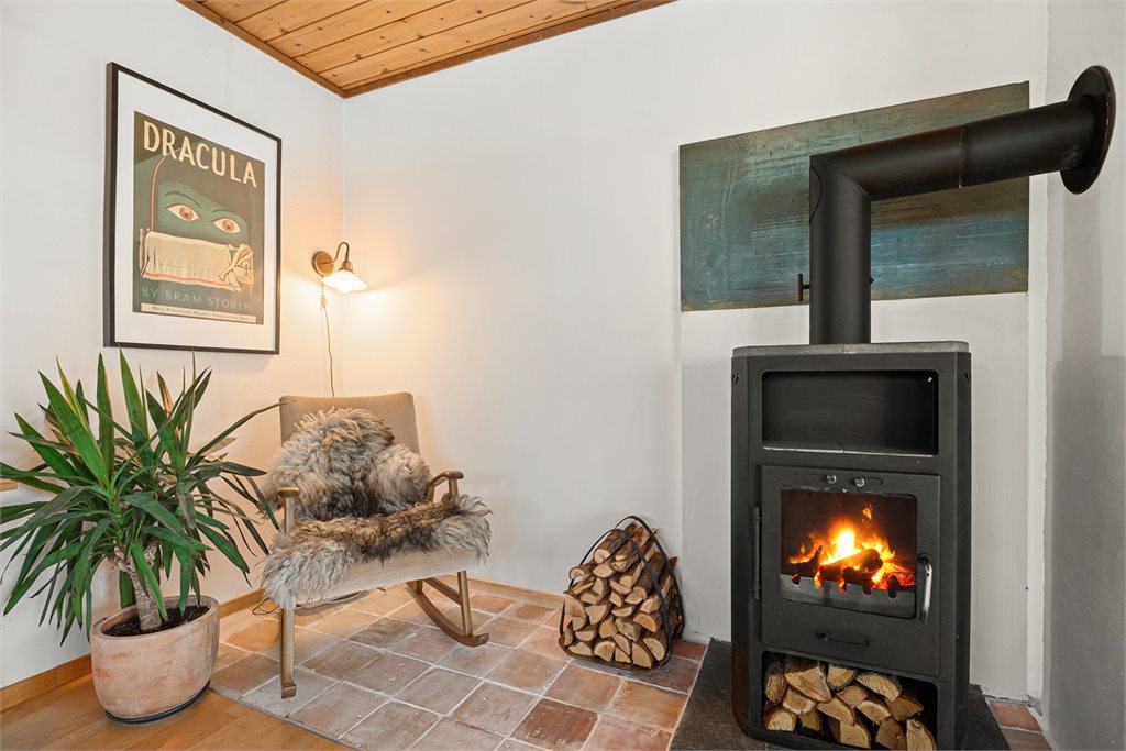 Stemningsfull peisplass med lune materialvalg.
