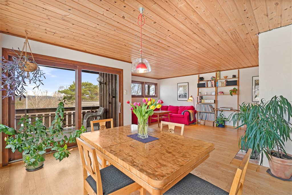 Spiseplass med nydelig lysinnslipp og utsyn mot naturen.
