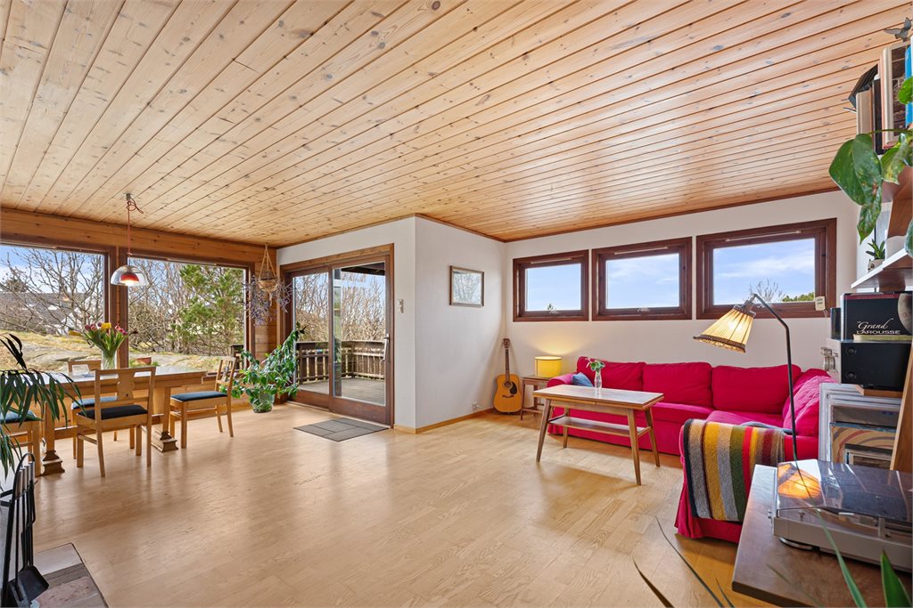 Åpen stue og spiseplass med utgang til terrasse.